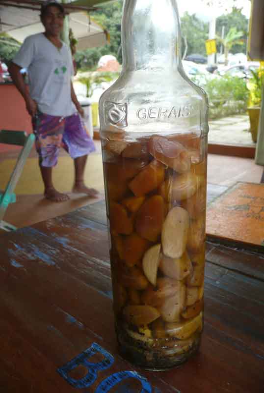 large bottle of cachaca stuffed full of fat cloves of garlic